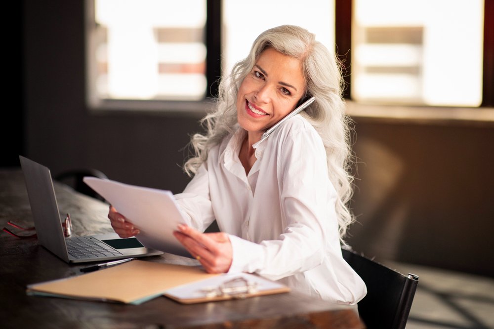 Person holding files while talking on cellphone.