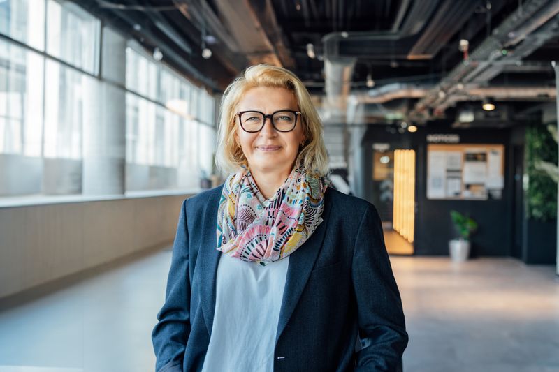 Professional smiling while standing in modern indoor workplace.