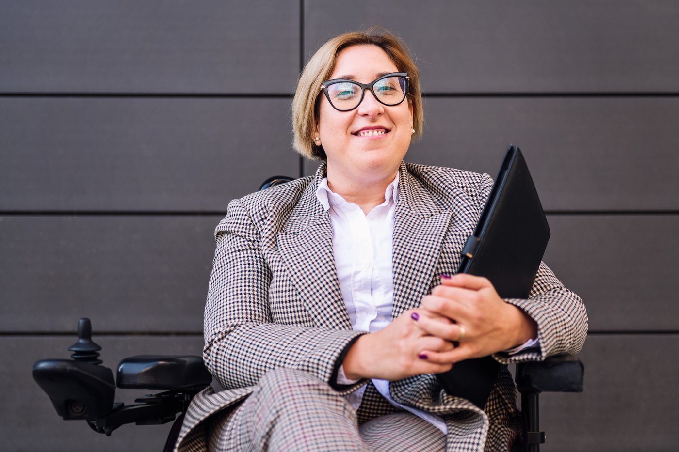 Student in wheelchair holding work folder.