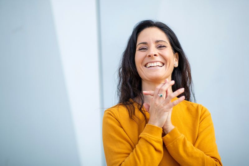 Person holding fingers clasped together with joy.