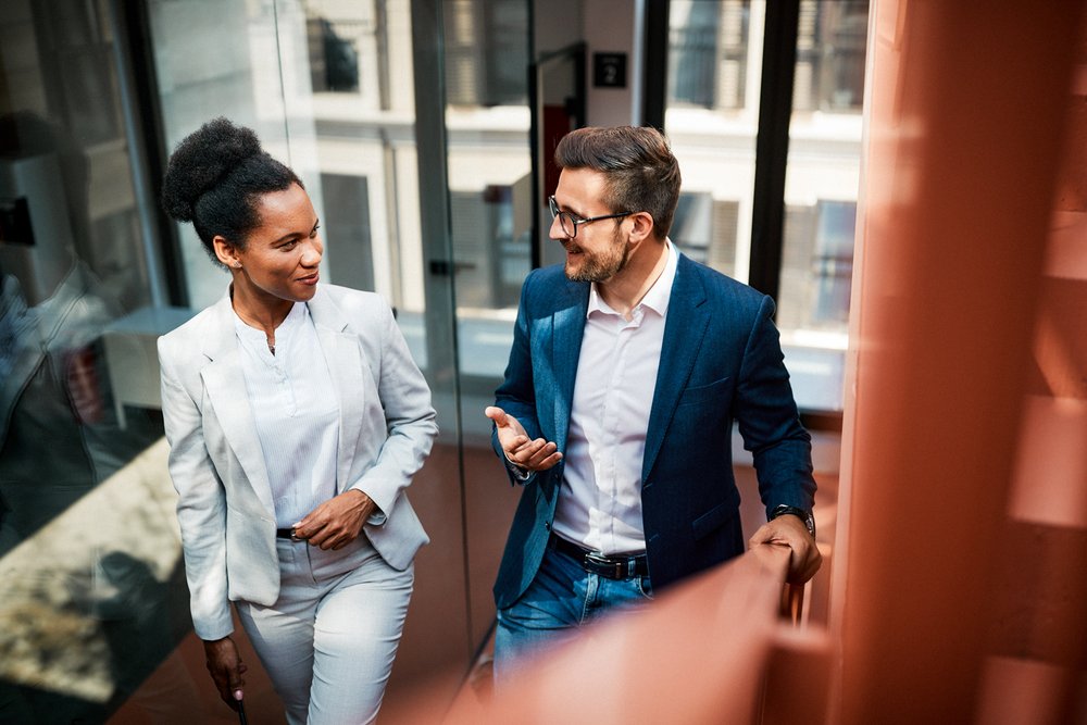 Colleagues having a conversation while walking up stairs.
