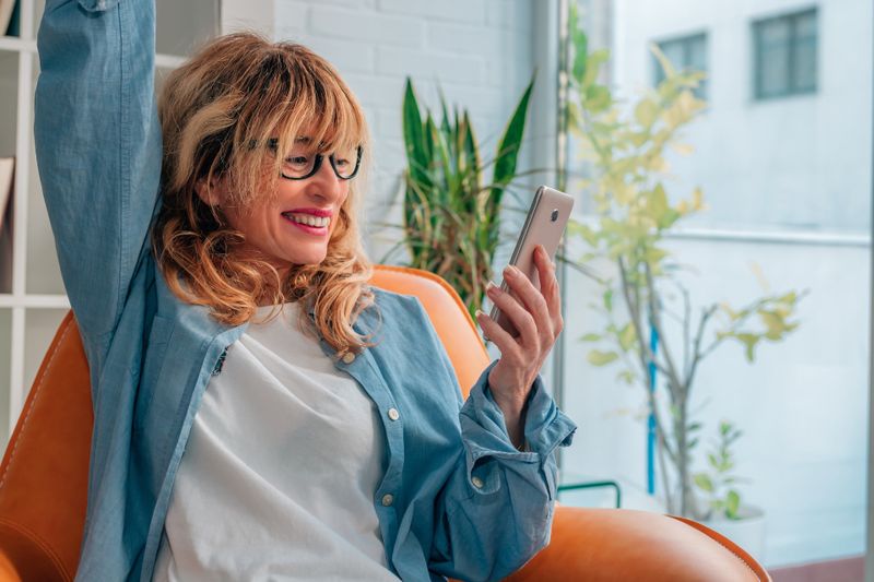 Person raising her hand in celebration during a video call.