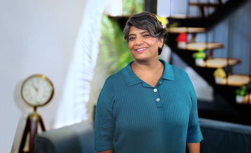 Student posing while standing in living room.