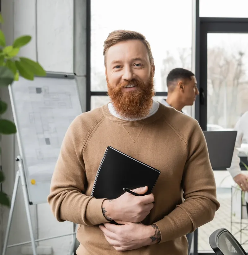 Person holding a notebook in an office setting.
