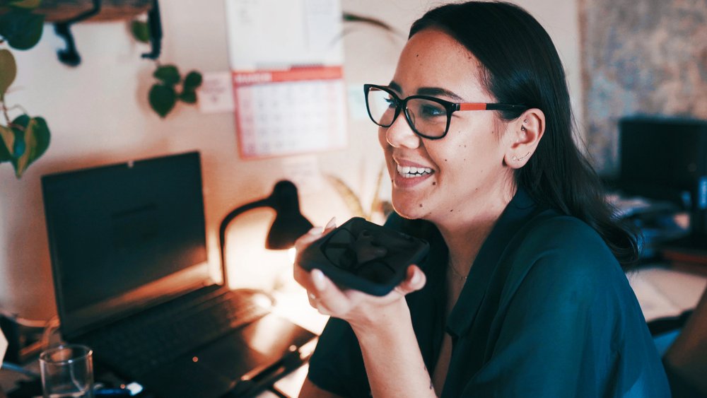 Student talking on phone in home office.
