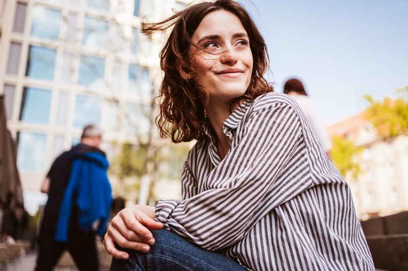 Person sitting outside looking confidently into the horizon.